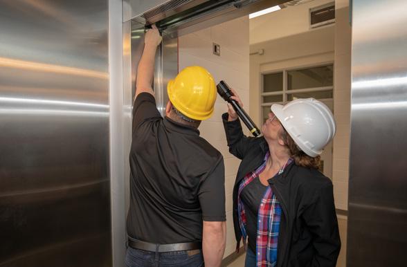 skilled trades professionals inspecting an elevator door