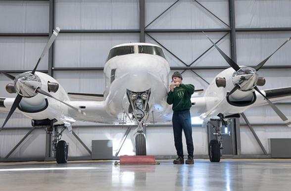 Mohawk College Student repairing a plane in an airport hangar