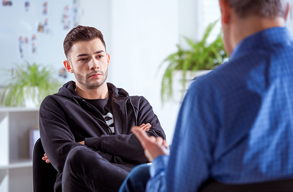 a young man being interviewed by a counsellor
