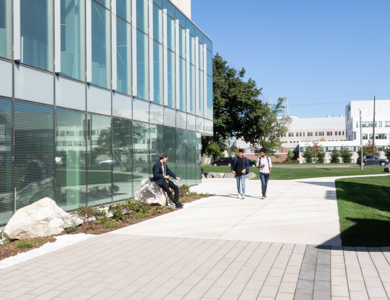 Exterior of Mohawk Fennell campus with students walking along a path.