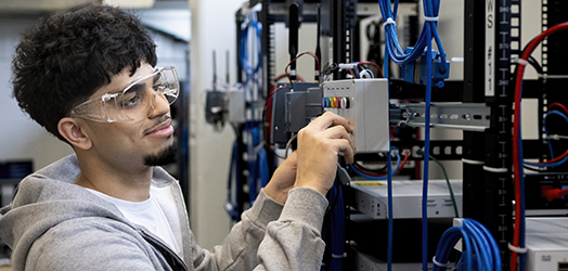 Mohawk College student working with network switches.