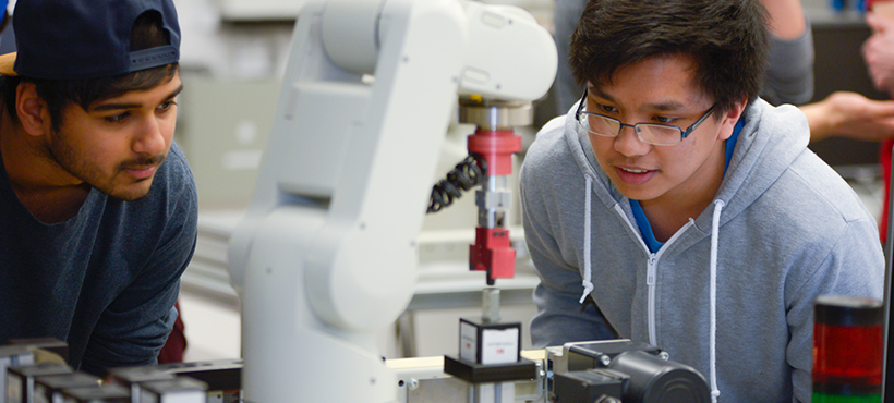 Two technology students working on machinery