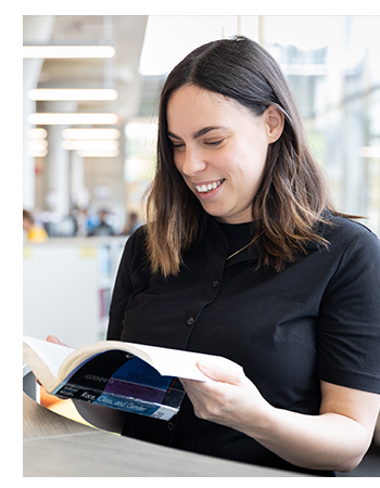 Lauren reading a book in the Mohawk College library