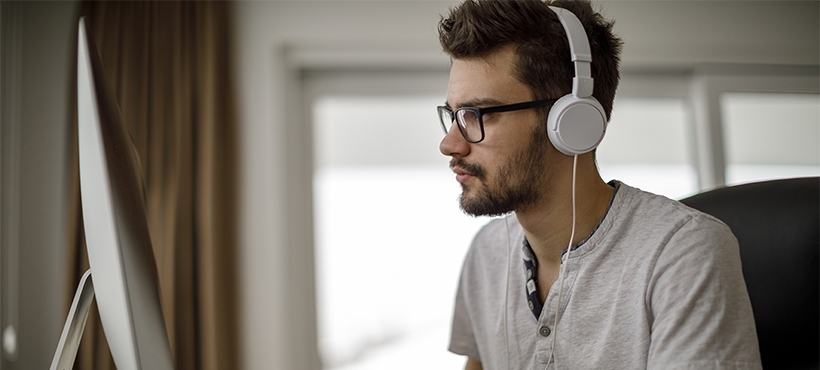 Student with headphones on computer