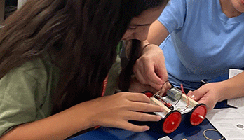 Mom and daughter assembling an electric car