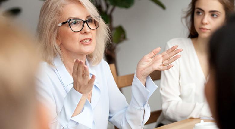 A woman sitting and talking to people in a group