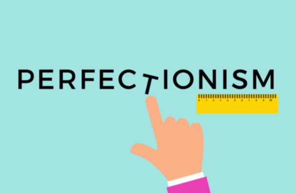 In the middle of the image is the word Perfectionism with a hand pointing at the letter T. 