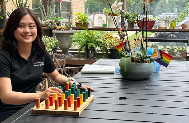 Mohawk student smiling while holding learning blocks.