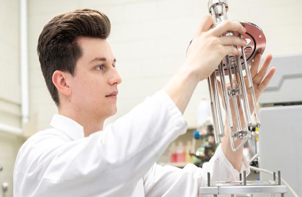 Luke adjusting an instrument in a lab.