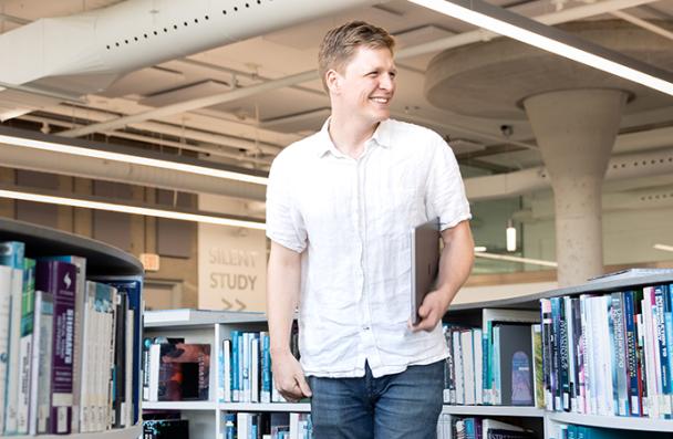 Mark smiling and posing at Mohawk College's library.