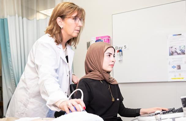 Faculty helping student with sonography